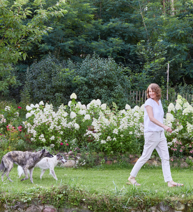 Cloud7 founder Petra Jungebluth pictured walking in her garden with her three dogs Matti, Freddie and Otto