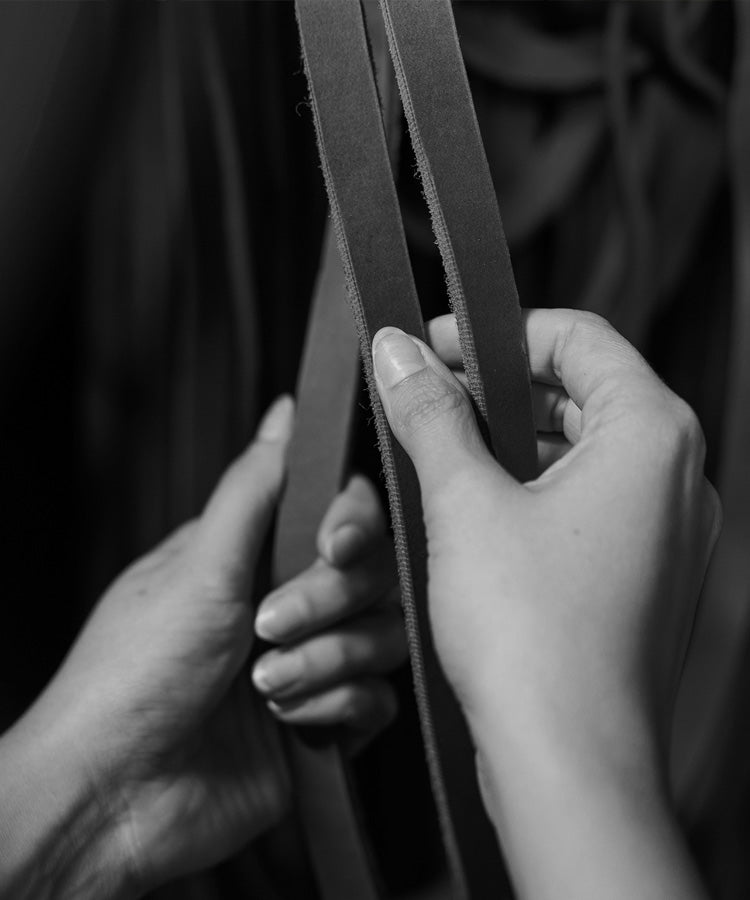 Hands sorting cut strands of leather