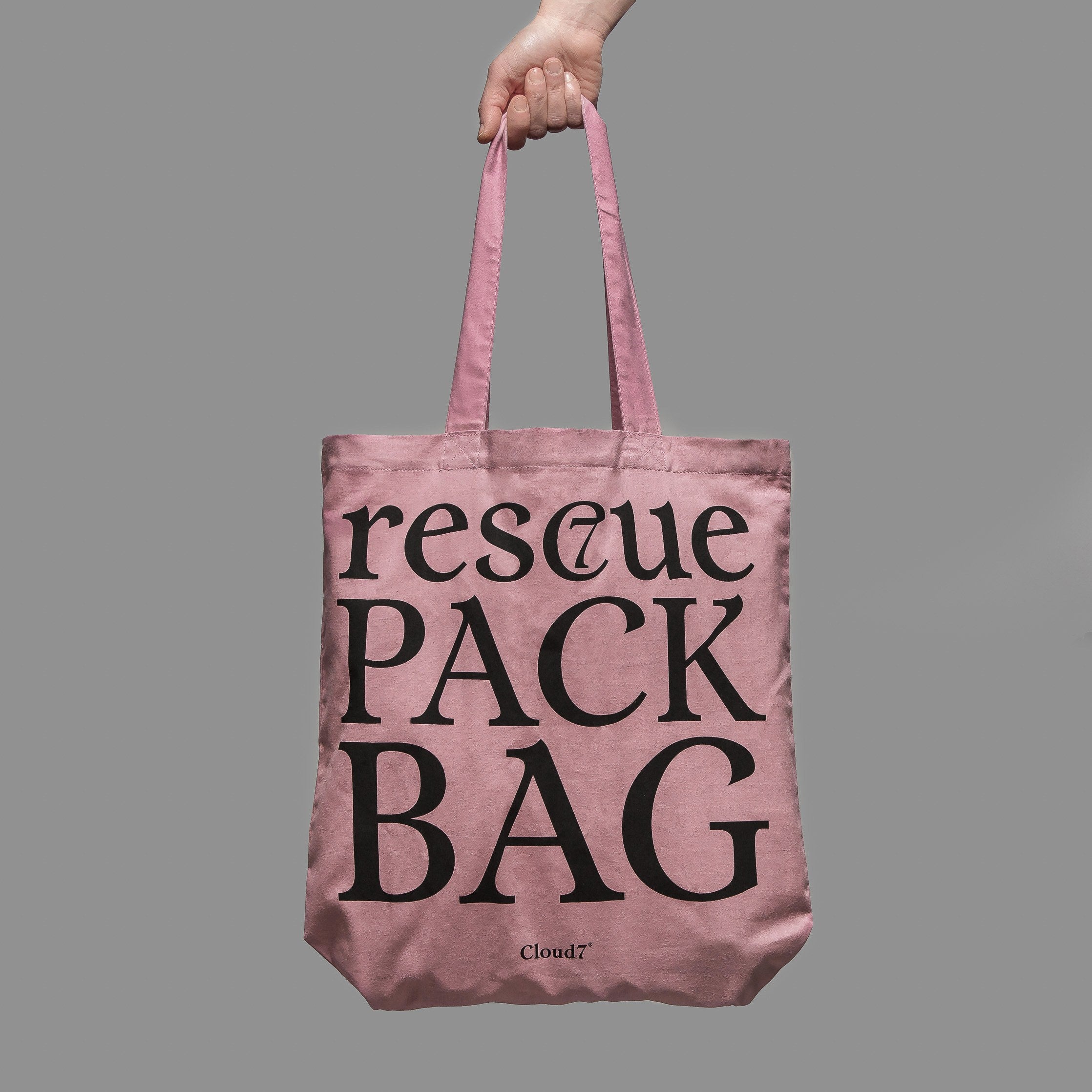 Hand hält rosa Statement Stofftasche