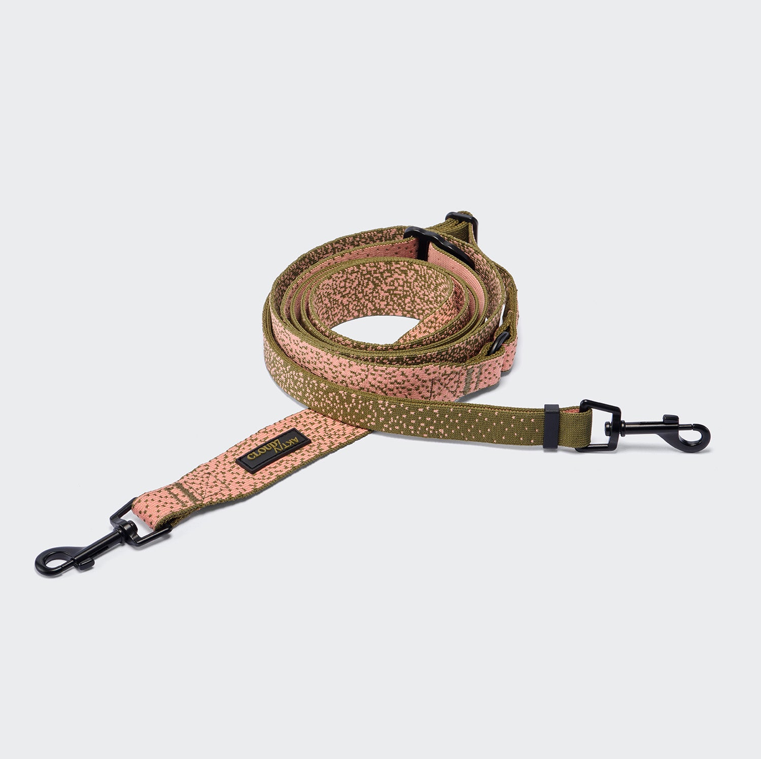 CLOUD7_ Eine aufgerollte L-3 Freihandleine AKTIV Knit in den Farben Khaki/Pfirsich mit gemustertem Design und schwarzen Metallklammern an beiden Enden, gefertigt aus Aktiv-Knit-Material und auf hellgrauem Hintergrund abgebildet.