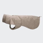Ein hellbrauner Hundemantel „Brooklyn Long Tweed Beige“ liegt flach ausgebreitet vor und zeigt seinen hohen Kragen, den Reißverschluss sowie eine Seitentasche. Der Mantel verfügt über eine Öffnung für das Vorderbein und eine verlängerte Passform mit einem verlängerten Rückenteil.