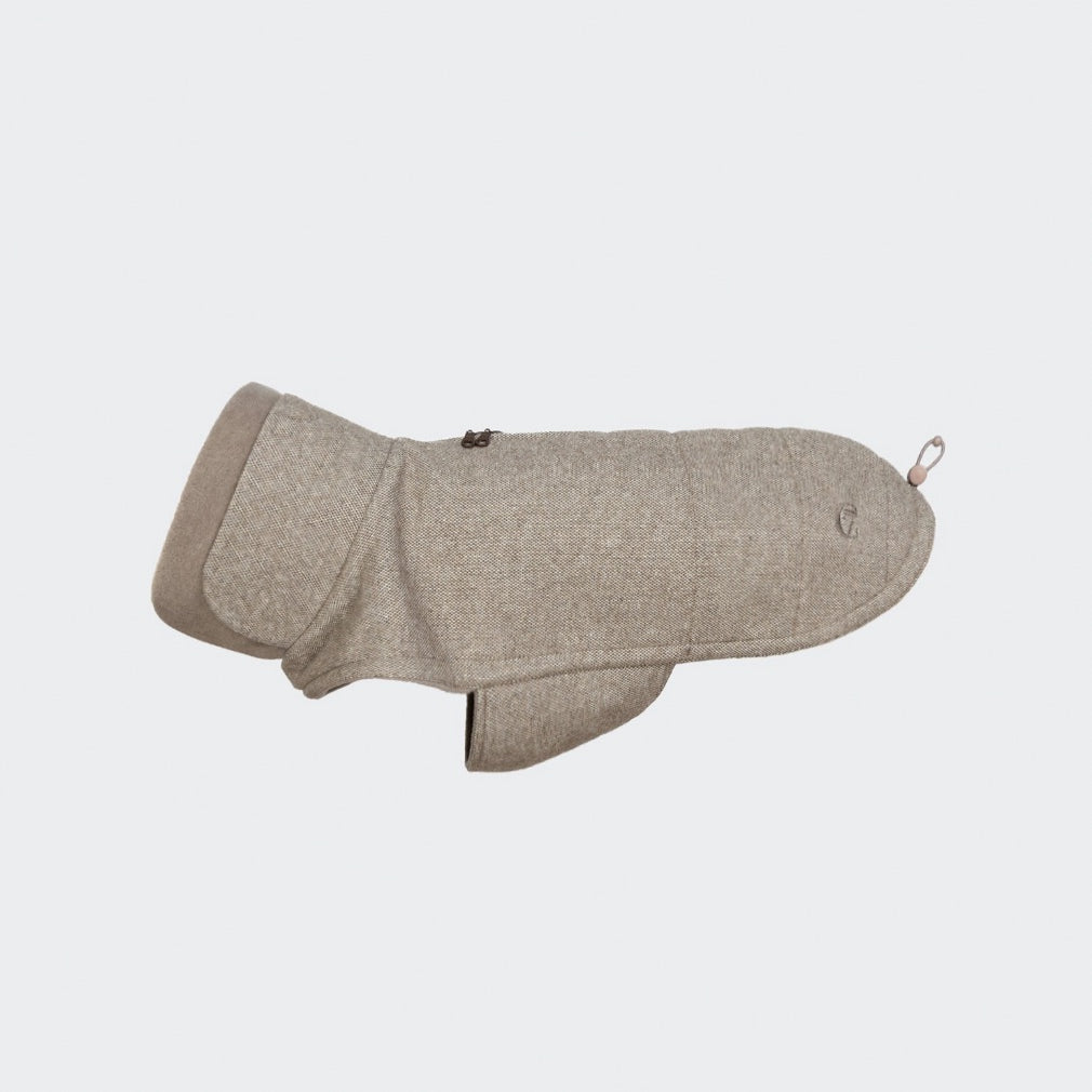 Ein beiger Hundemantel „Fr. Bulldogge Brooklyn Tweed“ mit Steppmuster, hohem Kragen und einem Reißverschluss oben, präsentiert vor einem schlichten, hellen Hintergrund.