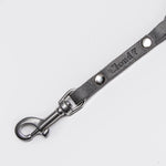 Silver carabiner and rivets of a grey braided leather leash for dogs