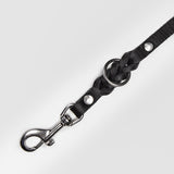 Details silver carabiner of a black leather dog leash