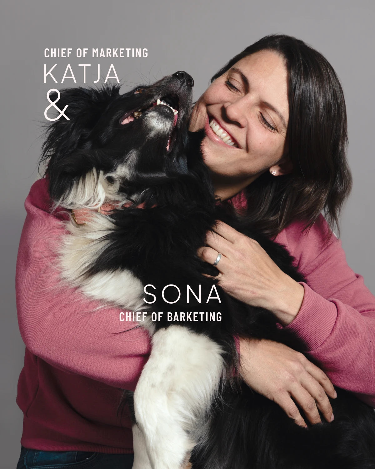 CLOUD7_ Eine Frau in einem rosa Pullover umarmt einen fröhlichen schwarz-weißen Hund. Beide sehen glücklich aus. Der Text lautet: „Marketingleiterin Katja & Sona, Leiterin der Hunde-Marketingabteilung.“.