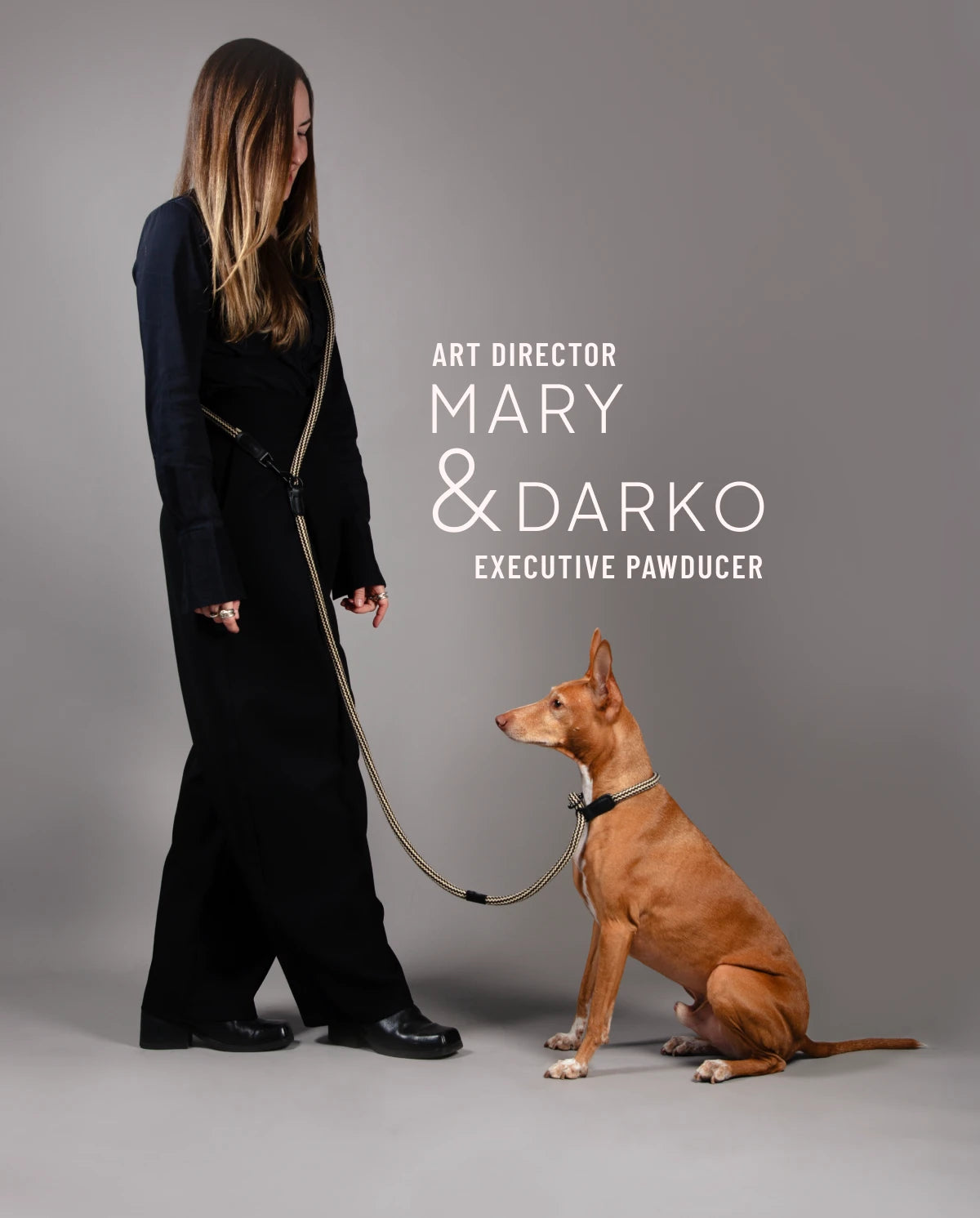 CLOUD7_ Eine Frau in Schwarz steht da und hält eine Leine in der Hand, an der ein brauner Hund sitzt und zu ihr aufblickt. Der Text lautet: Art Director Mary & Darko, Executive Pawducer.