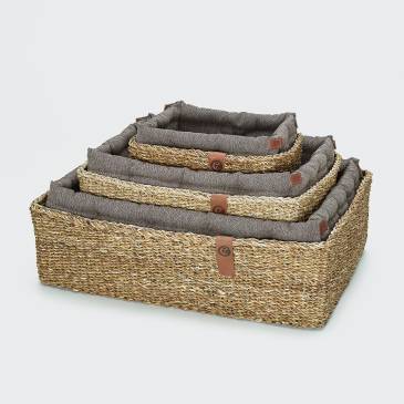 three dog baskets with brown pillows in different sizes