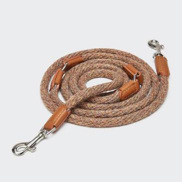 Rolled up textil dog leash with light brown leather elements and silver closure